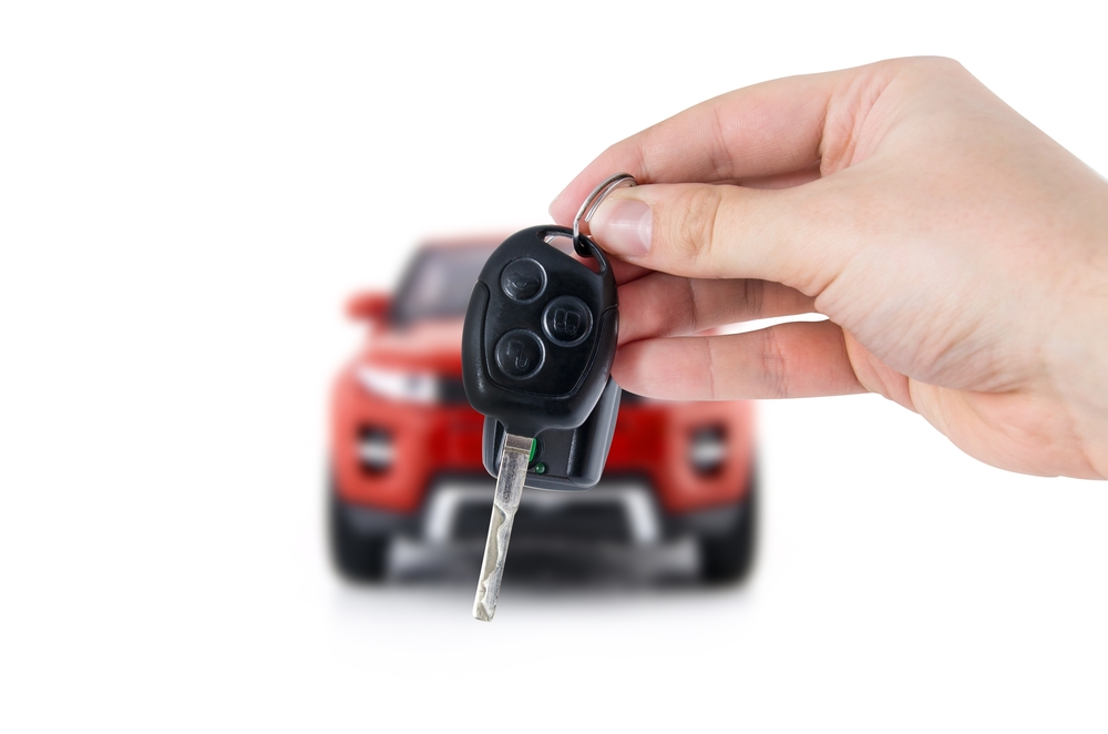 Hand,Holding,Keys,To,New,Red,Car.,Buy,Or,Selling